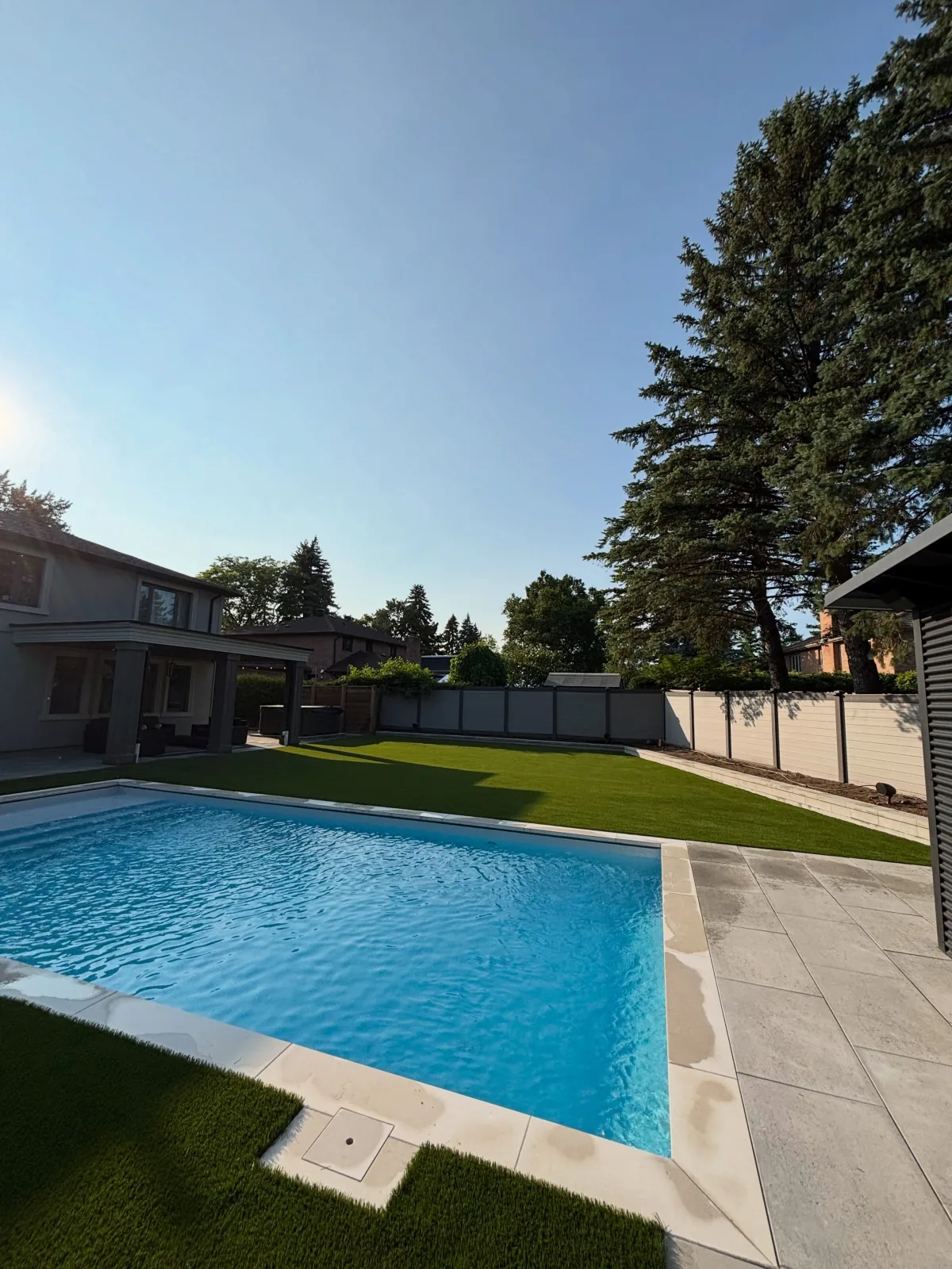 Artificial grass installed around a backyard pool in Brampton